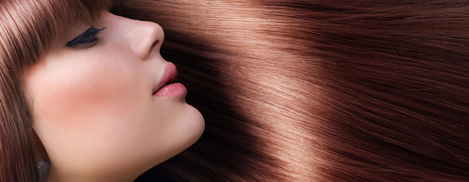 A woman with long brown hair is looking at the camera.