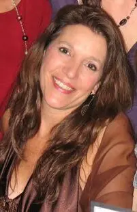 A woman with long hair smiling for the camera.